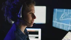 Closeup on female dispatcher focused on computer screens with rack focus