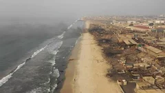 Accra, Jamestown coast, burning fires. Drone view, zoom in.