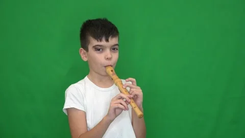 13 brunette boy in a white jacket plays the recorder Stock Footage 266450675