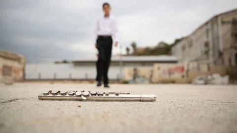 13 years old boy bending over and Picks up a flute from the floor. Slow Motion Stock Footage 118061553