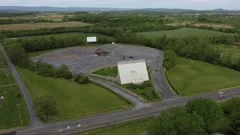 Aerial backing away from a drive-in movie theater showing the vast American