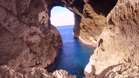 13150slow motion of looking out from closeup to the Lover's cave up to ocean hor Stock Footage 346589321