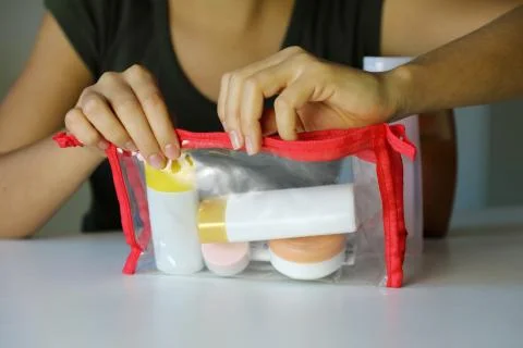 Woman  closing  trasparent  bag  with  travel  kit  for  transporting  cosmetics  on  airplane xkwx accessories,  accessory,  airplane,  airport,  bottle,  care,  clean,  clear,  closing,  compact,  concept,  container,  control,  copy  space,  cosmetic,  cosmetics,  cream,  fingers,  gel,  hands,  holidays,  hygiene,  inspection,  kit,  liquid,  lotion,  makeup,  object,  packing,  plastic,  portable,  pour,  prepare,  product,  security,  set,  shampoo,  shower,  small,  soap,  toiletry,  toothbrush,  toothpaste,  tourist,  transparent,  transporting,  travel,  traveler,  vacation,  woman