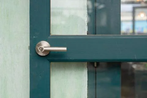 ด้วยมือจับประตูอลูมิเนียมประตูสีเขียวสามารถเปิดได้ในห้องถัดไป Stock Photos