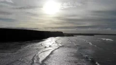 High to low angle moving shot over watergate bay in Cornwall, UK at Sunset
