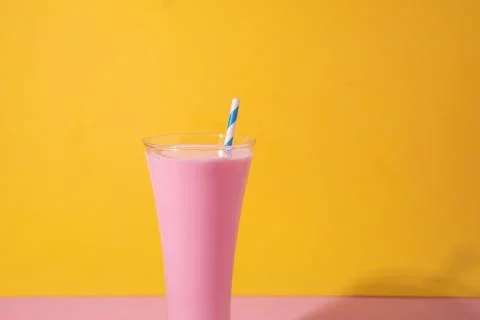 A  glass  of  strawberry  smoothie  isolated  on  yellow  and  pink  background xkwx fruit,  diet,  berry,  strawberry,  drink,  healthy,  nutrition,  food,  fresh,  blended,  vitamin,  milkshake,  background,  summer,  smoothie,  sweet,  dessert,  refreshment,  juicy,  juice,  glass,  pink,  isolated,  straw,  beverage,  horizontal,  yellow