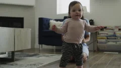 Slow motion of mother applauding baby daughter taking first steps / Bluffdale,