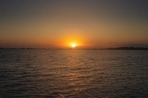 A colorful sunset over a bay or lake with a calm water surface. Late ...