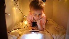 Portrait of little smart boy reading big story book at night. Child playing in
