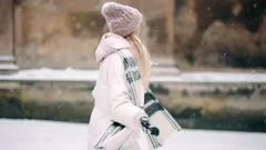 As the snow falls from the sky, a beautiful blonde woman starts playing