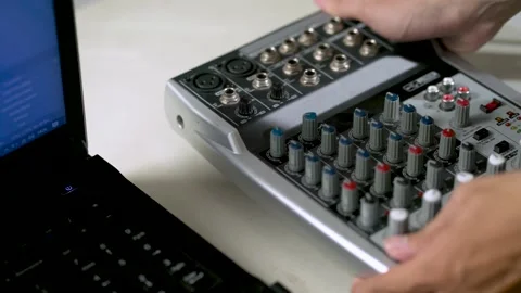 14_close-up hand putting audio or sound mixer next to the laptop ready Video stock 156024014