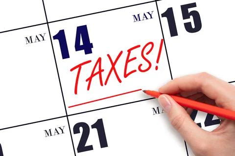 14th day of May. Hand drawing red line and writing the text Taxes on calendar Stock Photos