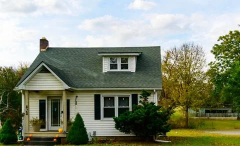 This is a 1.5-story Cape Cod-style single-family home with white siding Stock Photos