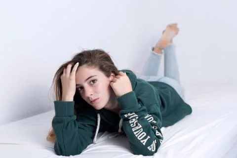 15-year-old adolescent lying on her bed Stock Photos