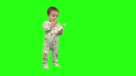 1.5 year old drinks from his bottle, then exits screen right. Stock Footage 49864471