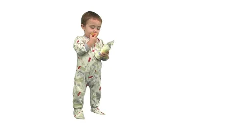 1.5 year old drinks from his bottle, then exits screen right. Stock Footage 49864474