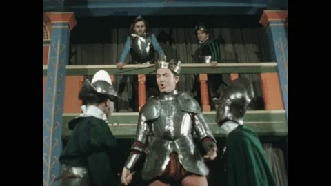 1500s: Low angle, men in period costume acting on stage. Clapboard. Man giving Stock Footage 165606502