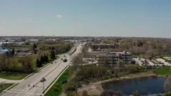 Aerial drone view of american higway in suburb at summertime. Establishing shot