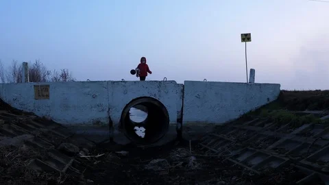 155 Bridge child in a respirator red jacket with a toy and a black ball, fea Stock Footage 124362053