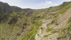 Smooth aerial descent past the cliff faces of Mount Snowden in Snowdonia