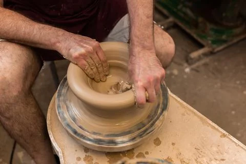 Crop unrecognizable sculptor with equipment giving shape while sculpting with brown clay on throwing wheel xkwx man, shape, clay, sculpt, equipment, process, motion, jug, ceramic, skill, male, sculptor, workshop, art, artist, handicraft, earthenware, ceramist, craft, create, dirty, form, hobby, handmade, maker, master, molding, occupation, pottery, utensil, wet, wheel, professional, work, artisan, throw, small business, talent, workplace, crop, unrecognizable, faceless, anonymous, horizontal, body part, blur, indoors, top view, from above