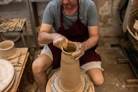 Crop unrecognizable sculptor with equipment giving shape while sculpting with brown clay on throwing wheel xkwx man, shape, clay, sculpt, equipment, process, motion, jug, ceramic, skill, male, sculptor, workshop, art, artist, handicraft, earthenware, ceramist, craft, create, dirty, form, hobby, handmade, maker, master, molding, occupation, pottery, utensil, wet, wheel, professional, work, artisan, throw, small business, talent, workplace, crop, unrecognizable, faceless, anonymous, horizontal, body part, blur, indoors