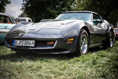 DIEDERSDORF,  GERMANY  -  AUGUST  21,  2021:  The  sports  car  Chevrolet  Corvette  Stingray  (C3).  Focus  on  center.  Swirly  bokeh.  The  exhibition  of  "US  Car  Classics". xkwx america,  american,  ancient,  antique,  auto,  automobile,  automotive,  car,  classic,  design,  diedersdorf,  exhibition,  germany,  machine,  model,  nostalgia,  old,  oldtimer,  retro,  style,  transport,  transportation,  us,  usa,  vehicle,  engine,  sports  car,  Chevrolet,  Corvette,  coupe,  2-door,  c3,  Vette,  muscle  car,  exterior,  Stingray,  Focus,  center,  Swirly,  bokeh