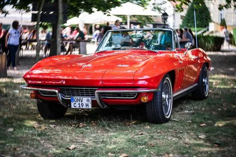 DIEDERSDORF,  GERMANY  -  AUGUST  21,  2021:  The  sports  car  Chevrolet  Corvette  Sting  Ray  Convertible  (C2).  Focus  on  center.  Swirly  bokeh.  The  exhibition  of  "US  Car  Classics". xkwx america,  american,  ancient,  antique,  auto,  automobile,  automotive,  car,  classic,  design,  diedersdorf,  exhibition,  germany,  machine,  model,  nostalgia,  old,  oldtimer,  retro,  style,  transport,  transportation,  us,  usa,  vehicle,  vintage,  exterior,  2-door,  sports  car,  Chevrolet,  Corvette,  Sting  Ray,  Convertible,  C2,  second  generation,  GM,  General  Motors,  muscle  car,  Focus,  center,  Swirly,  bokeh