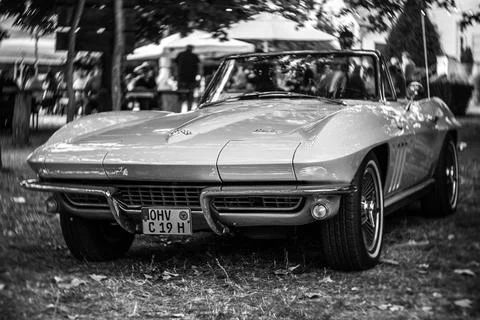 DIEDERSDORF,  GERMANY  -  AUGUST  21,  2021:  The  sports  car  Chevrolet  Corvette  Sting  Ray  Convertible  (C2).  Focus  on  center.  Swirly  bokeh.  Black  and  white.  The  exhibition  of  "US  Car  Classics". xkwx america,  american,  ancient,  antique,  auto,  automobile,  automotive,  car,  classic,  design,  diedersdorf,  exhibition,  germany,  machine,  model,  nostalgia,  old,  oldtimer,  retro,  style,  transport,  transportation,  us,  usa,  vehicle,  vintage,  exterior,  2-door,  sports  car,  Chevrolet,  Corvette,  Sting  Ray,  Convertible,  C2,  second  generation,  GM,  General  Motors,  muscle  car,  Focus,  center,  Swirly,  bokeh,  black,  white