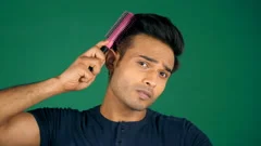A college student combing and brushing his hair getting ready for a party