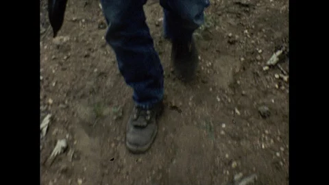 16mm man walks through forest toward camera Stock Footage 129862632