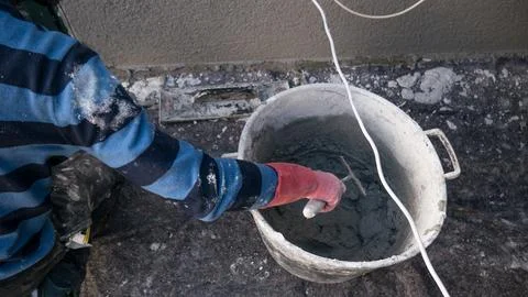 17-02-2024-Plastering bricklayer working on a wall throwing mortar on the wall Foto stock