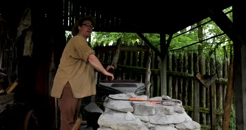 1770s American Frontier Blacksmith Reenactor operates a bellows for his fire Stock Footage 311791244