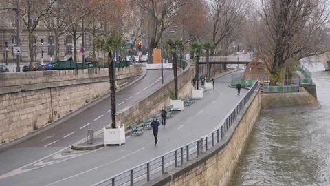 18 Rainy gray winter day Paris sports people running the Sena embankment in t Stock Footage 100814156