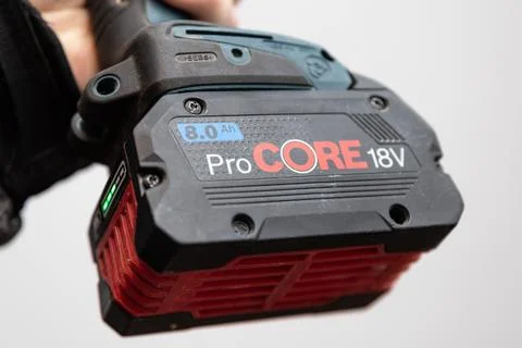 18 volt battery Pro Core on a cordless drill in the worker's hand Stock Photos