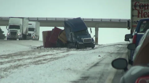 18-wheeler lands in medium after sliding off snow highway. Stock Footage 54756970