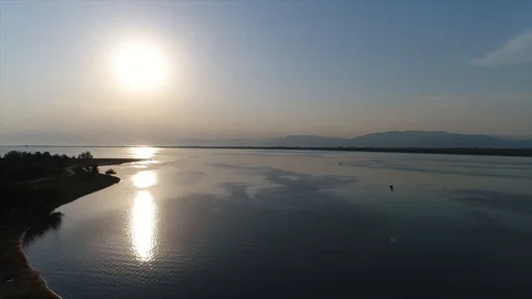 180 degree aerial shot with drone over a sea and beach with the sun shining, 4K Stock Footage
