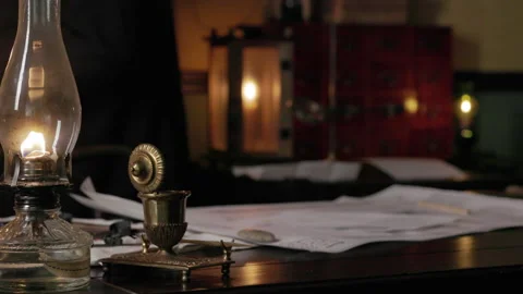 1800s man working in back of lamp lit cluttered desk being the focus Stock Footage 336746977