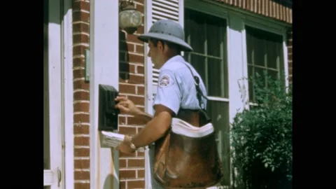 1880s: Mailman is delivering mail to mailbox at home and pauses to look at door. Stock Footage 220809802