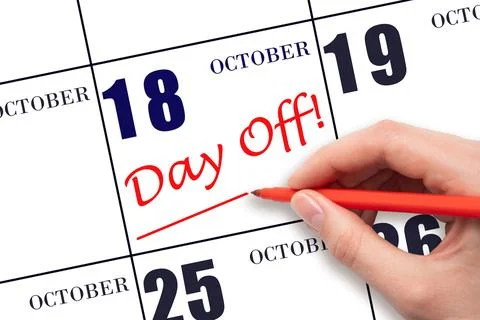 18th day of October. Hand writing text DAY OFF and drawing a line on calendar Stock Photos