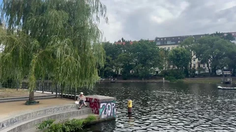 19, July, 2026, Berlin Germany: Old Woman Sitting By River Berlin Germany Stock Footage 340108130