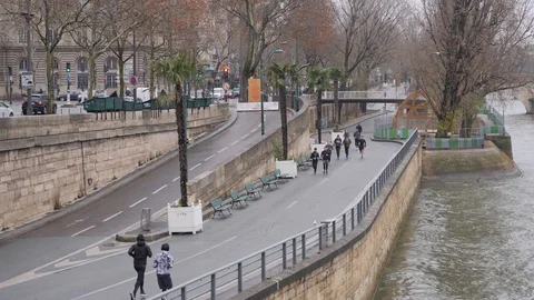 19 Rainy gray winter day Paris sports people running the Sena embankment in t Stock Footage 100814100