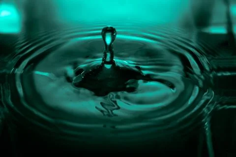 190.Teal water drop collision creating a fluid splash Stock Photos