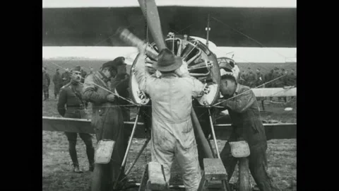 1910s: Army mechanics remove propeller and nose cone from a Sopwith Camel plane Stock Footage 215917417