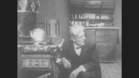 1910s: Father and daughter converse. Father and daughter work in kitchen. Stock Footage