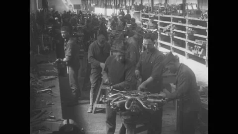 1910s: Men construct biplane engines in factory workshop. Men test propellers Stock Footage 137404988