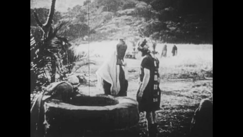 1910s: UNITED STATES: lady carries container of water from well. Ladies walk Stock Footage