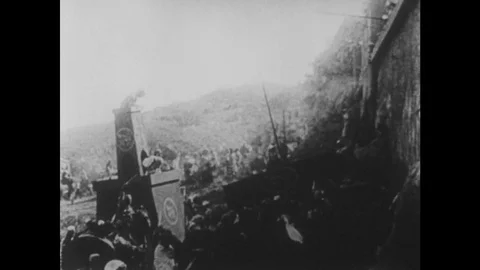 1910s: UNITED STATES: men attack city walls, Man sits on throne and waits. Stock Footage
