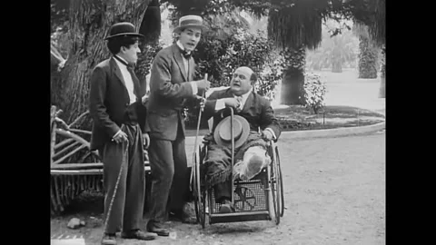 1914 - In this silent comedy, a couple laughs at a man (Charlie Chaplin) Stock Footage 246362076