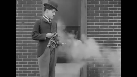 1914 - In this silent comedy, a man uses a gun to light his cigarette and Stock Footage 238773118